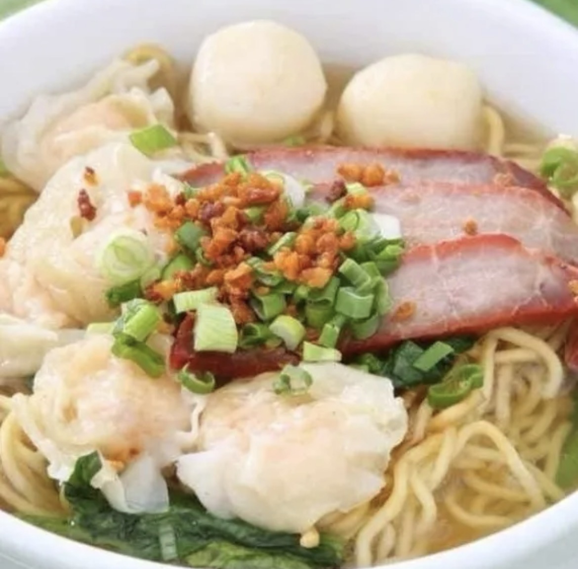 Two portions of noodles, shrimp and pork wontons, and fish balls